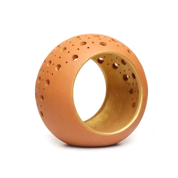 Handmade terracotta tealight holder with gold interior on white background