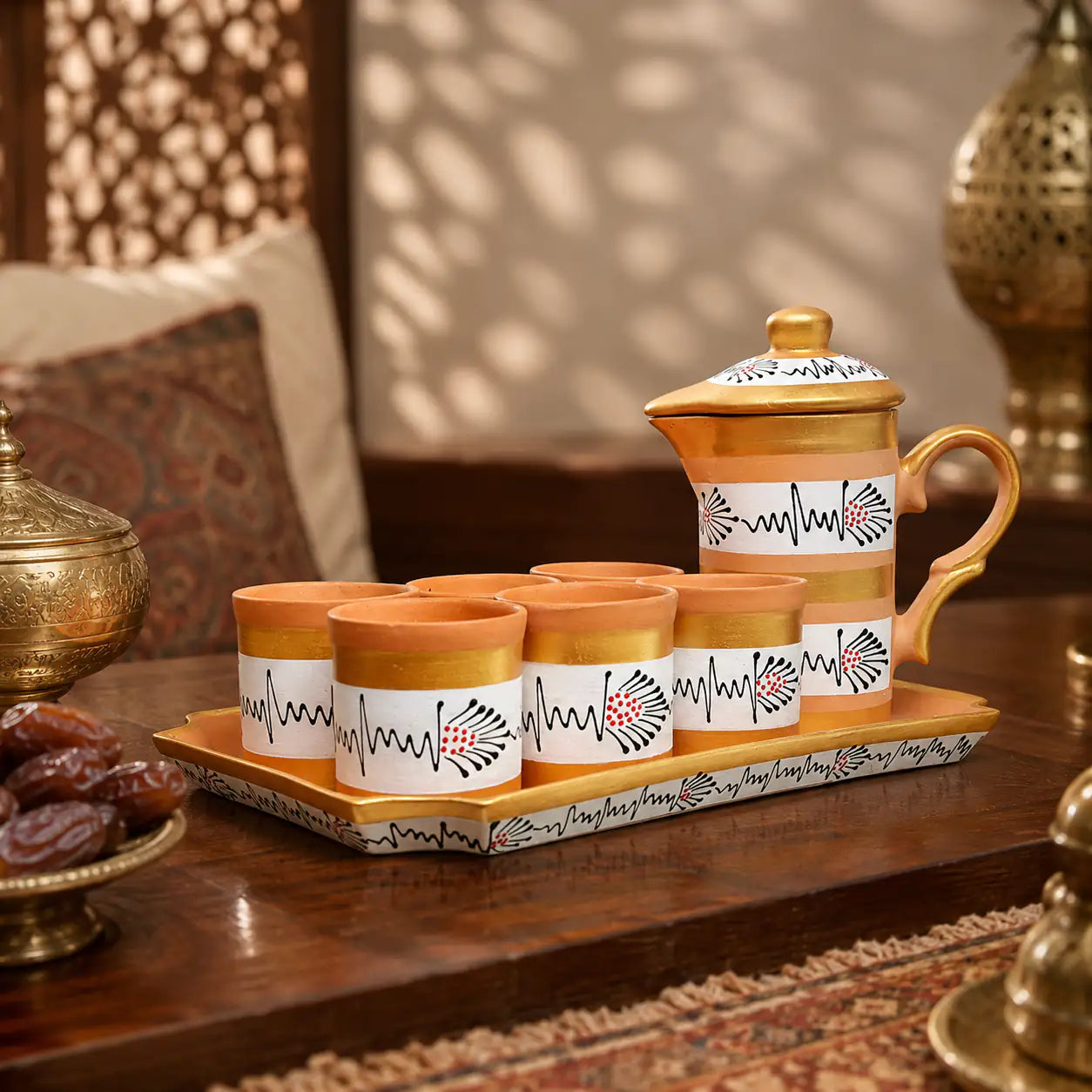 Clay tea set with cups and a teapot on a wooden table, with decorative elements in the background.