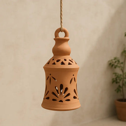 Terracotta hanging lantern with cut-out designs on a beige background