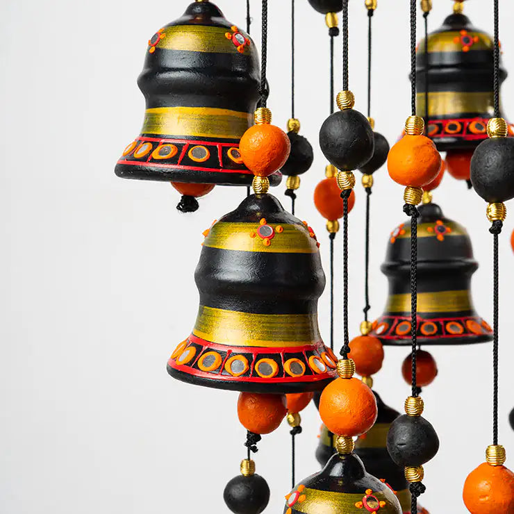 Decorative hanging bells with black, gold, and orange colors on a white background