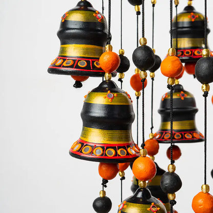 Decorative hanging bells with black, gold, and orange colors on a white background