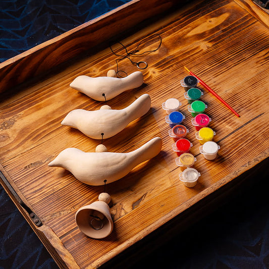 DIY clay bird painting kit for kids with handmade clay birds, paints, brush, beads, cord, and bell