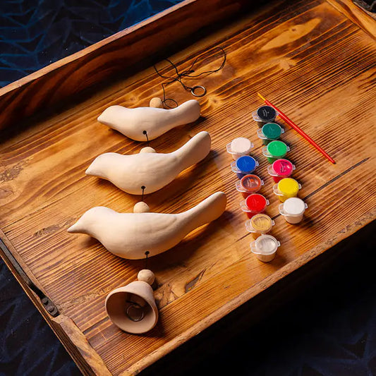 DIY clay bird painting kit for kids with handmade clay birds, paints, brush, beads, cord, and bell