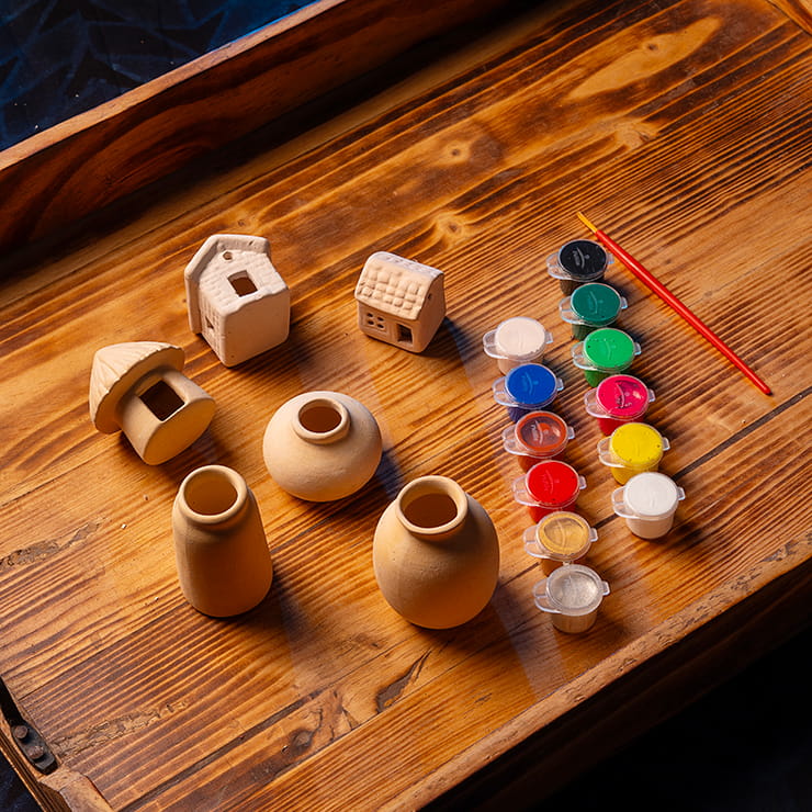 DIY clay mini village painting kit for kids with clay houses, hut, mini pots, paint pots, and brush