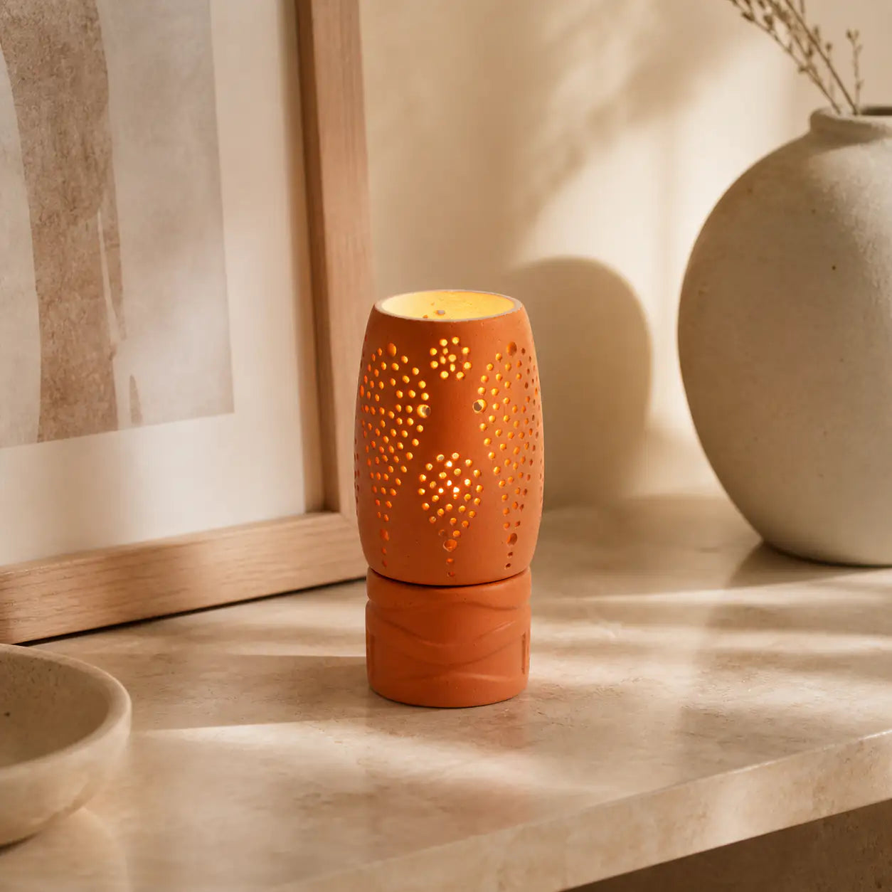 Handmade clay candle holder glowing on modern coffee table