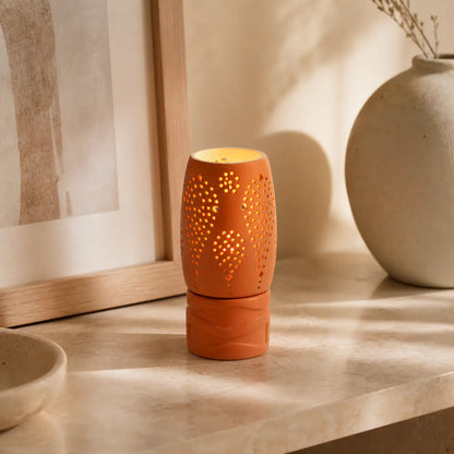 Handmade clay candle holder glowing on modern coffee table
