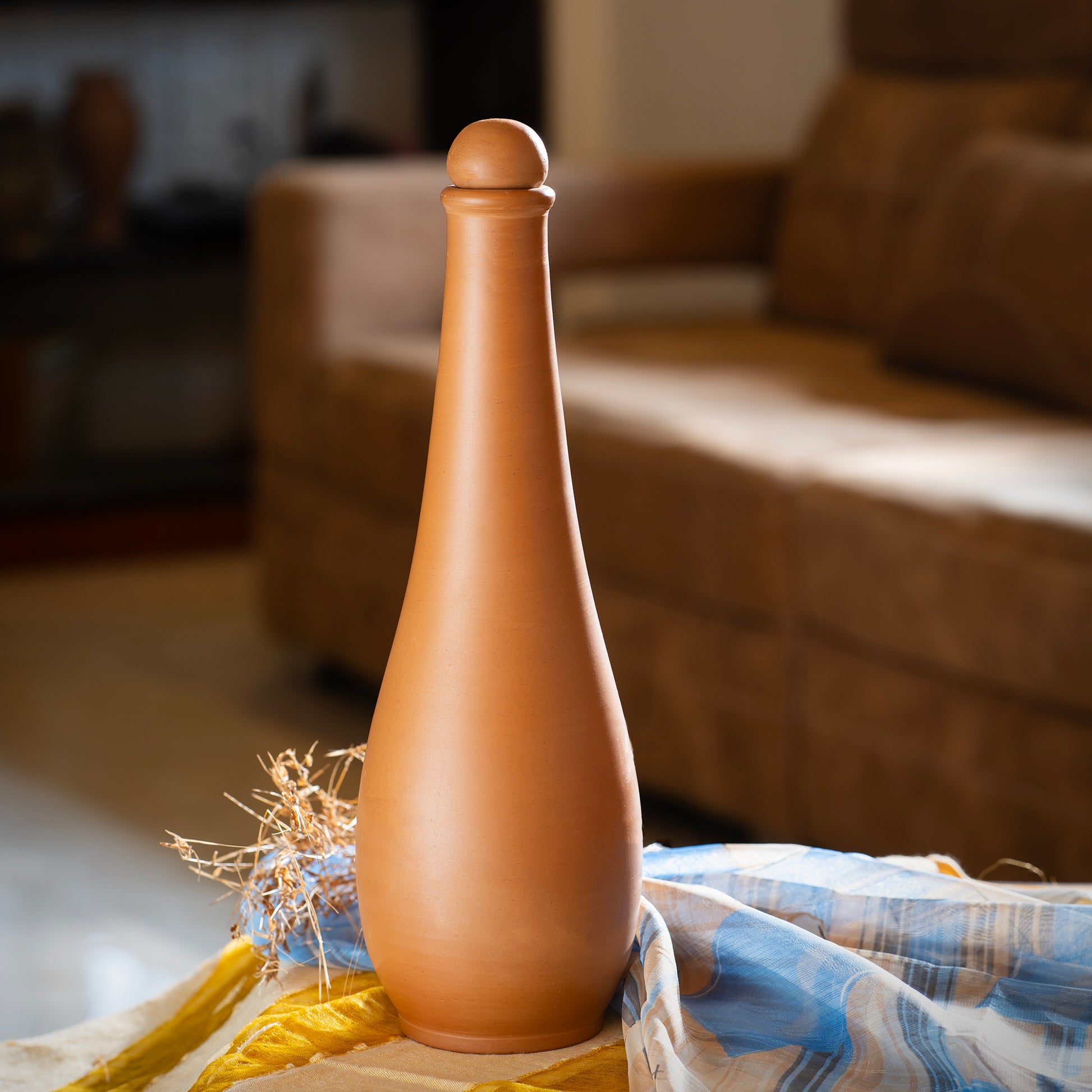 Crimson Noir tall terracotta water bottle styled in a warm modern home interior