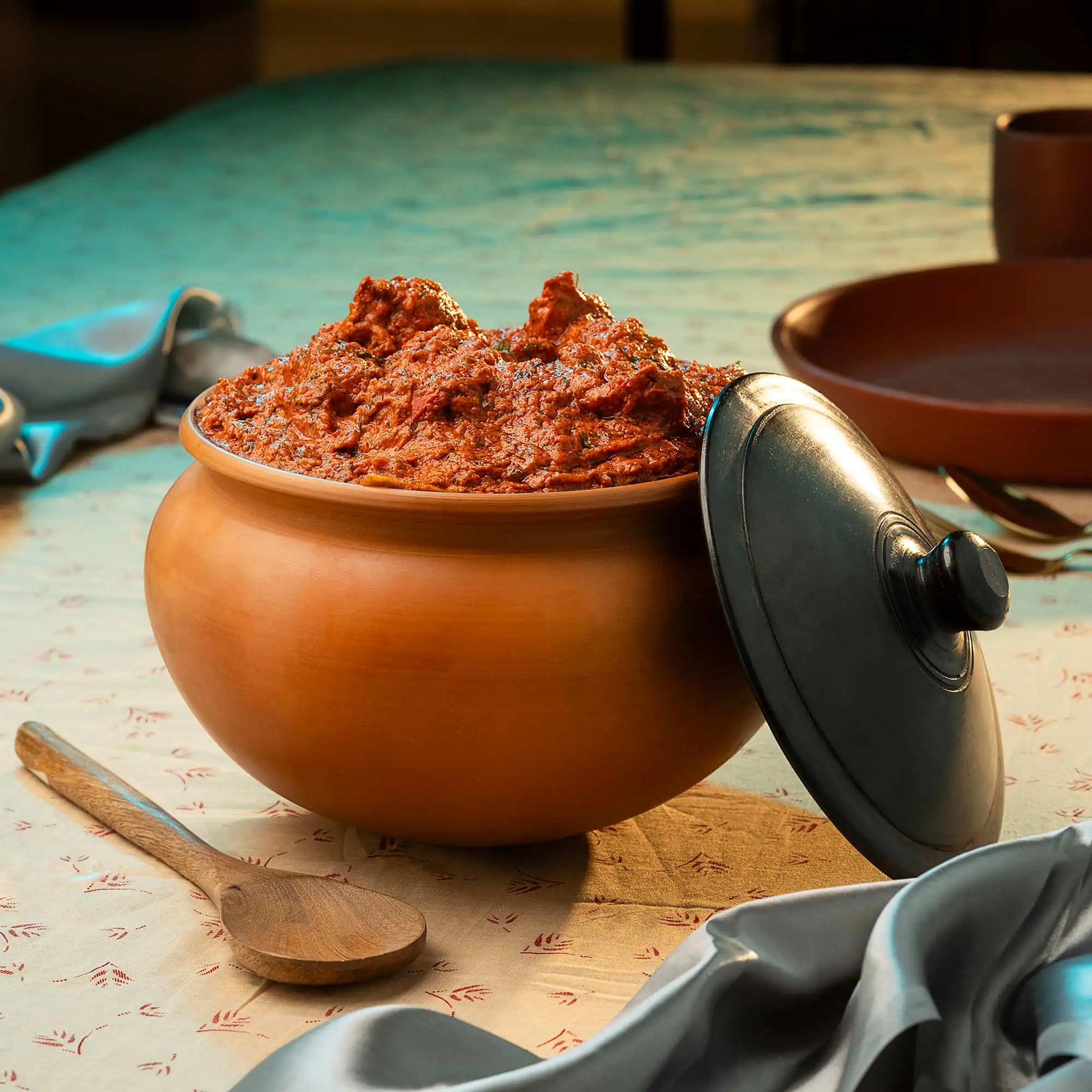 Terracotta Cooking pot with red paste on a wooden table