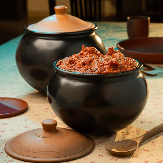 Black Terracotta pot with red spice on a patterned tablecloth