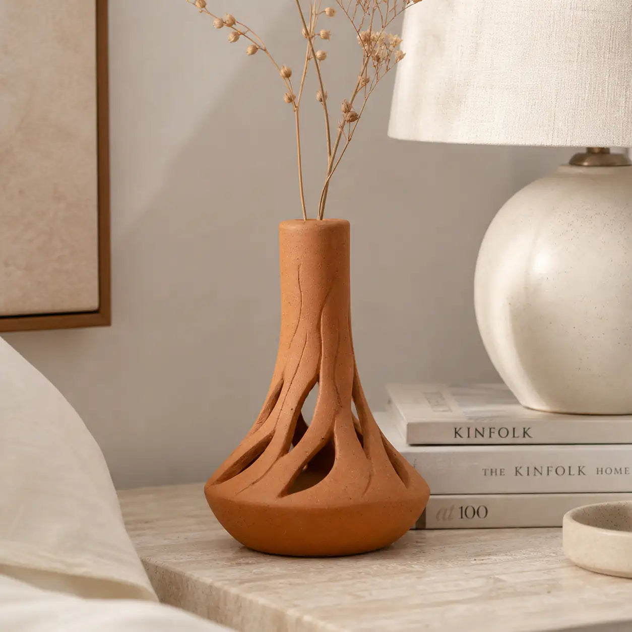 Amour Eclat Root Flow terracotta vase styled beside lamp and books
