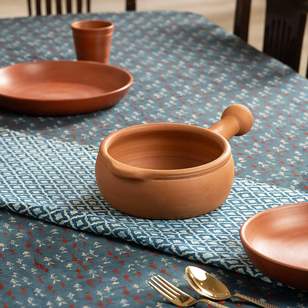 1 litre terracotta saucepan with handle styled on dining table