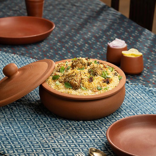 Natural clay biryani pot filled with rice and terracotta lid
