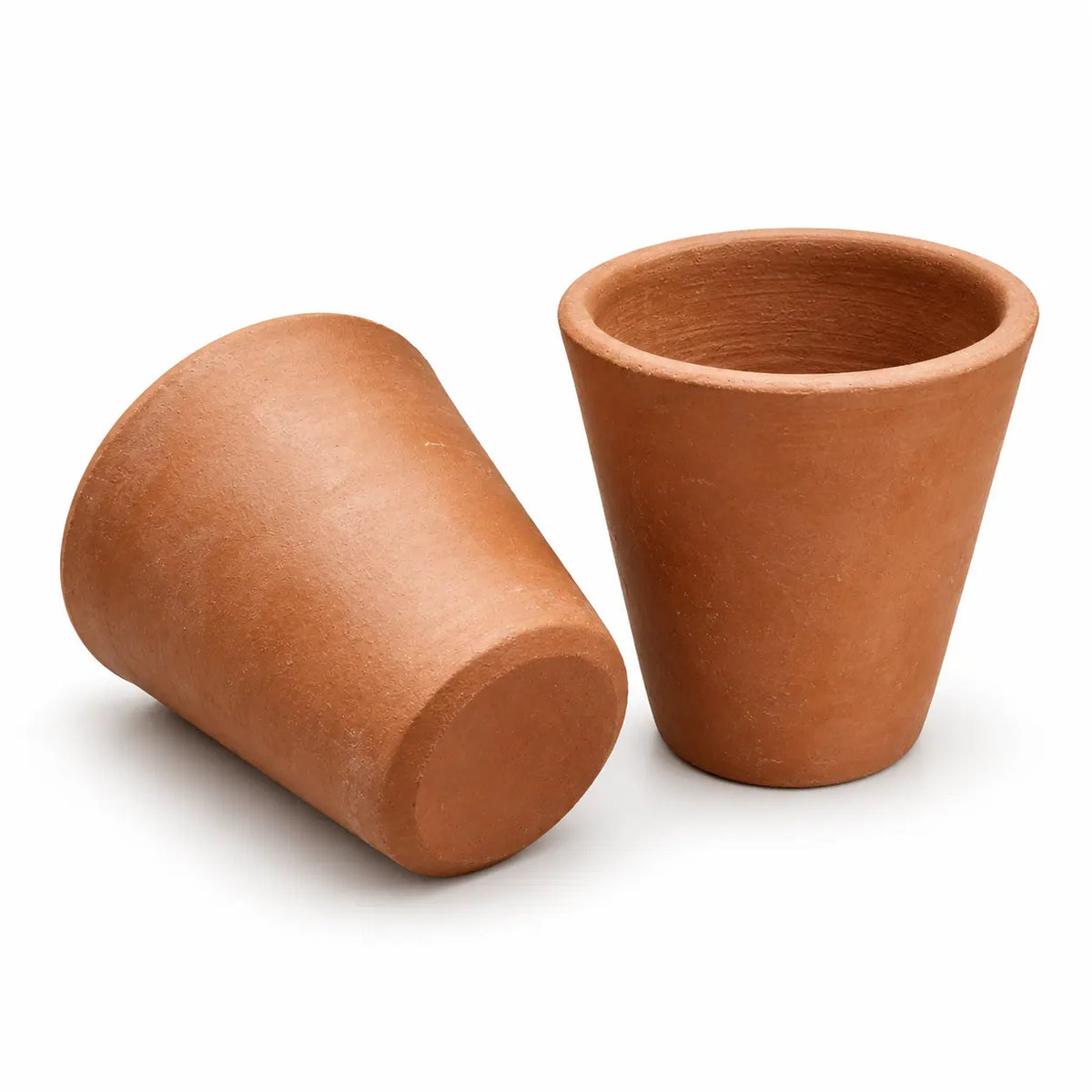 Two handmade clay drinking glasses showing natural terracotta texture and shape