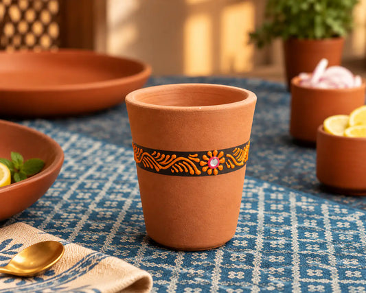 Hand-painted clay drinking glass from Terra Aseel on traditional dining table
