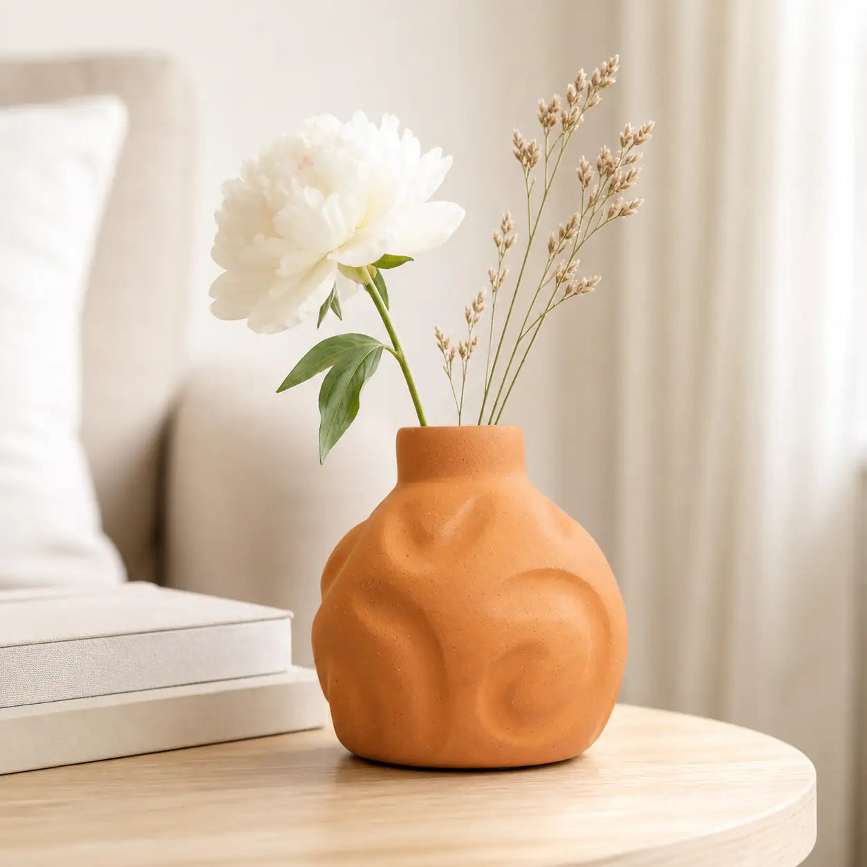 Handmade terracotta vase with white flowers styled on coffee table