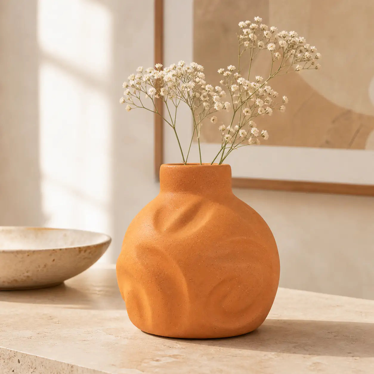 Handmade clay vase styled with white flower and dried stems