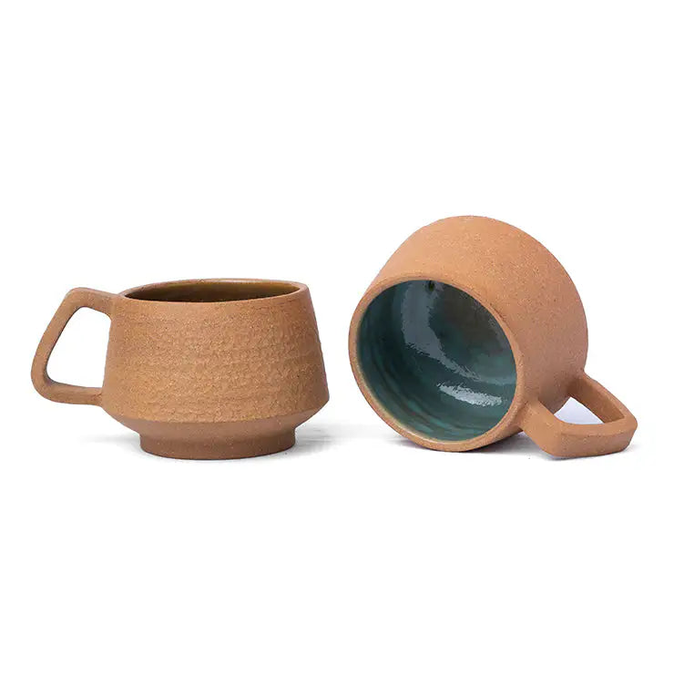 Small terracotta coffee cup with textured exterior and handle