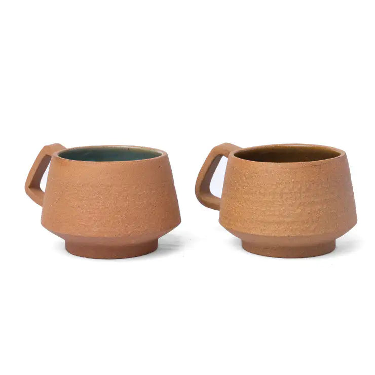 Small terracotta coffee cup with textured exterior and handle