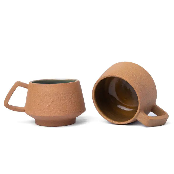 Small terracotta coffee cup with textured exterior and handle