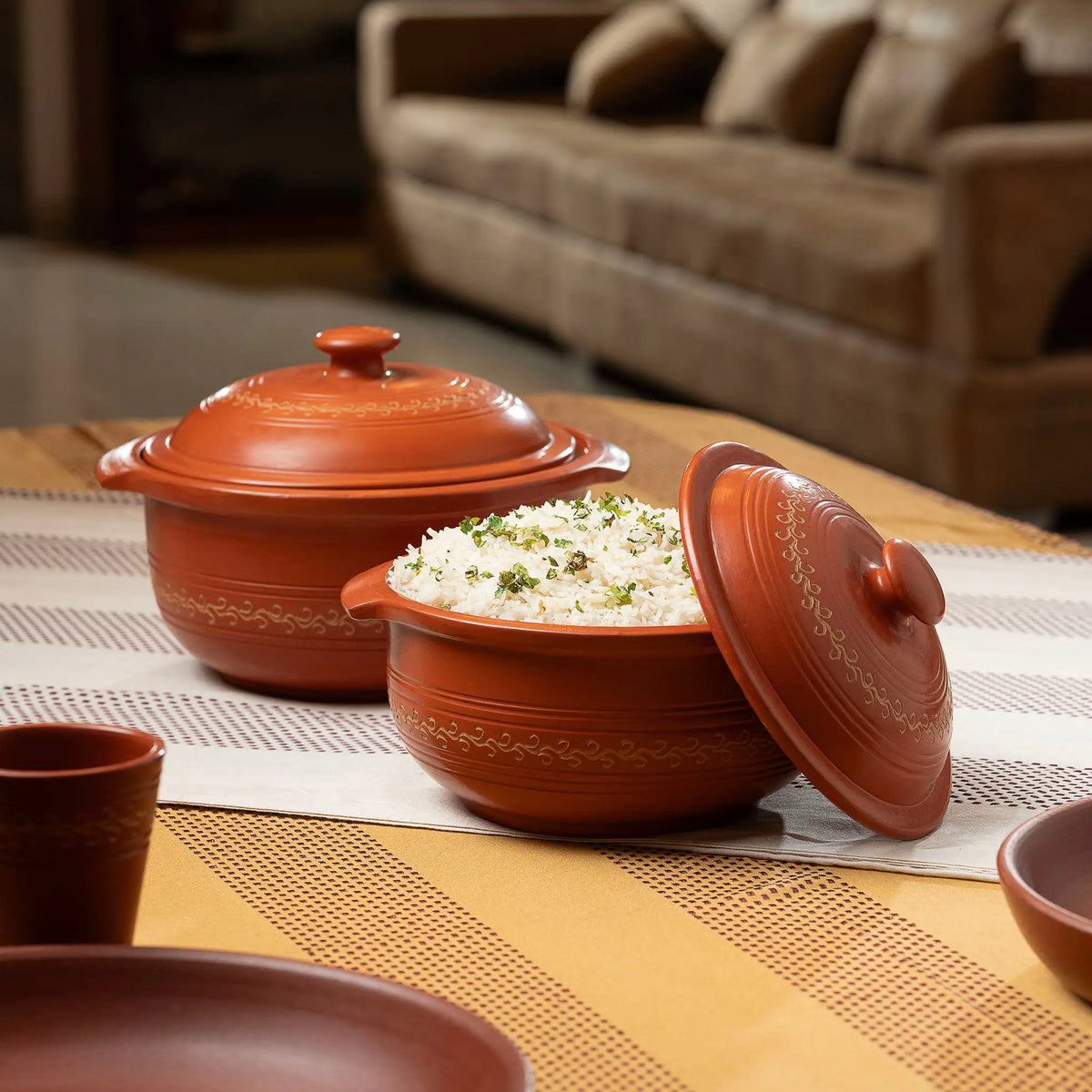 Terracotta serving pot with lid used to serve rice on dining table
