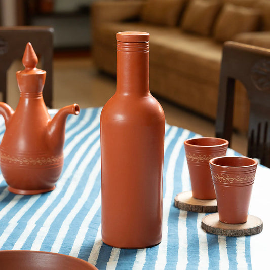 Handmade terracotta water bottle with clay lid styled on dining table