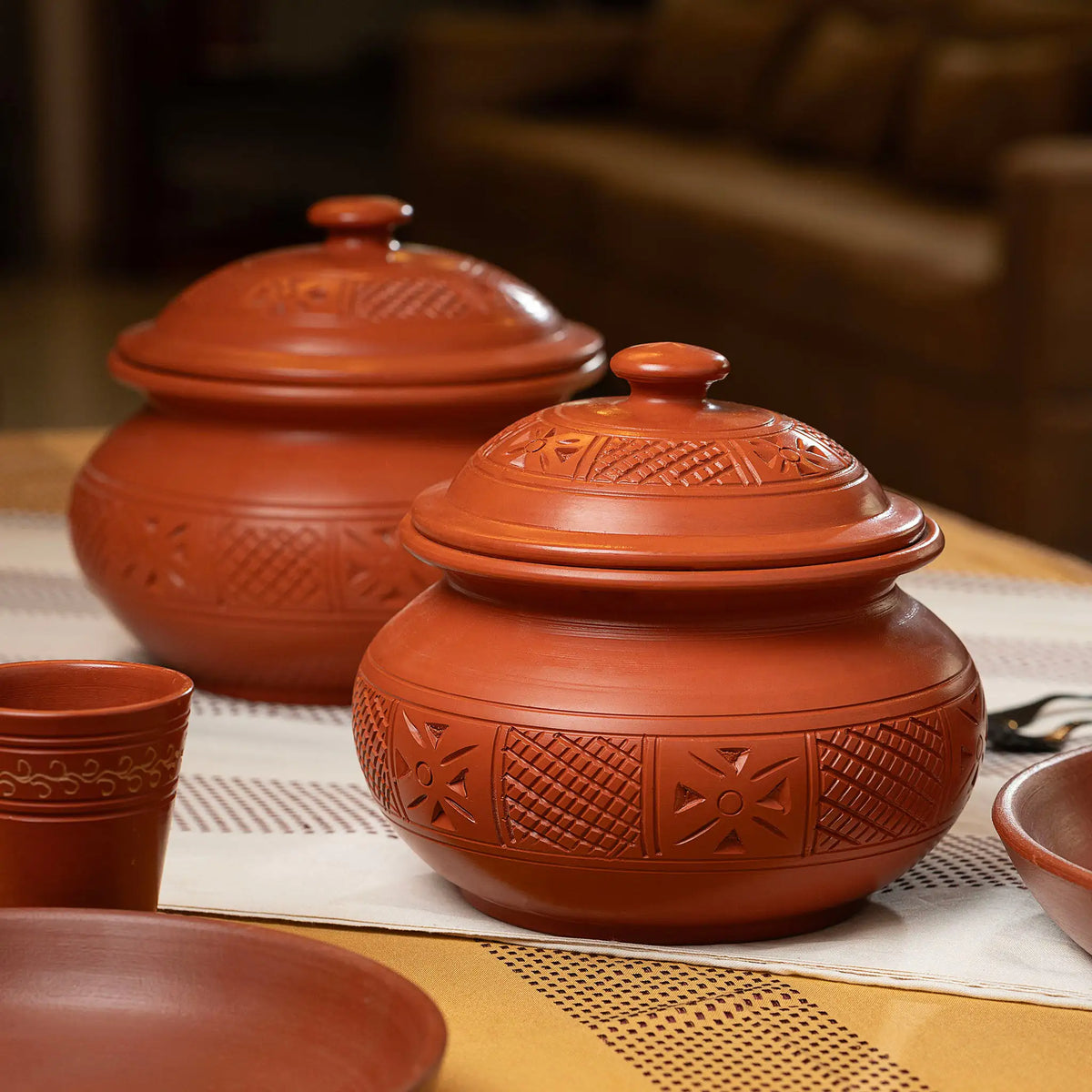 Terra Majlis carved terracotta serving pots with lids on dining table