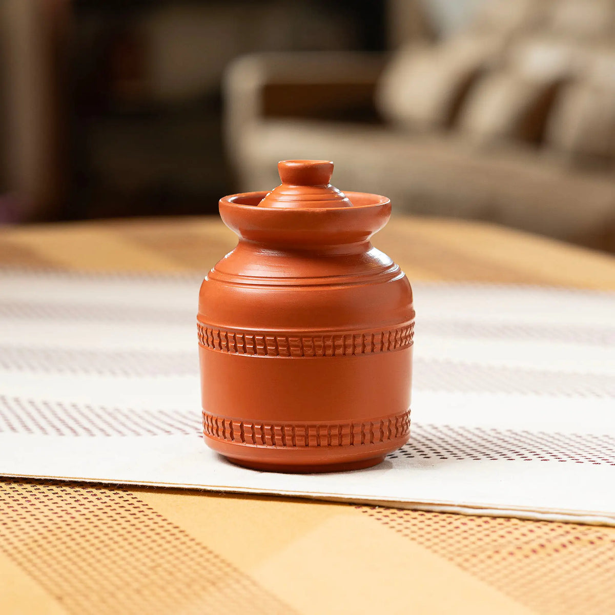 Small terracotta countertop storage jar in lifestyle setting