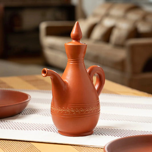 Handmade clay water jug with decorative detailing and terracotta lid