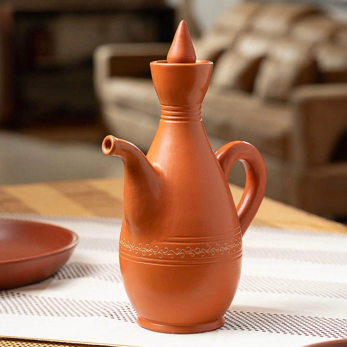 Terracotta serving pitcher with pointed clay lid for table use