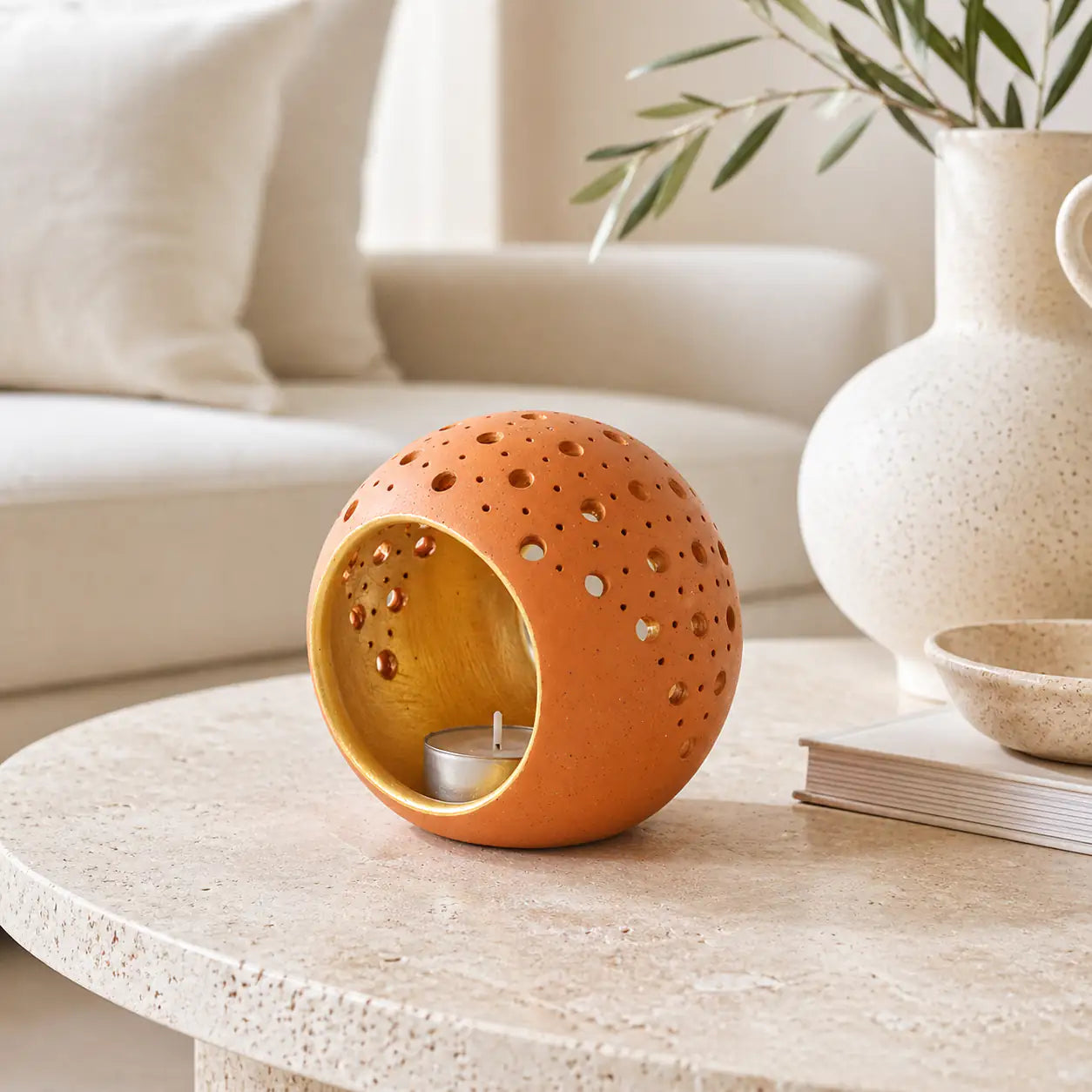 Terracotta cutwork candle holder styled on a modern coffee table