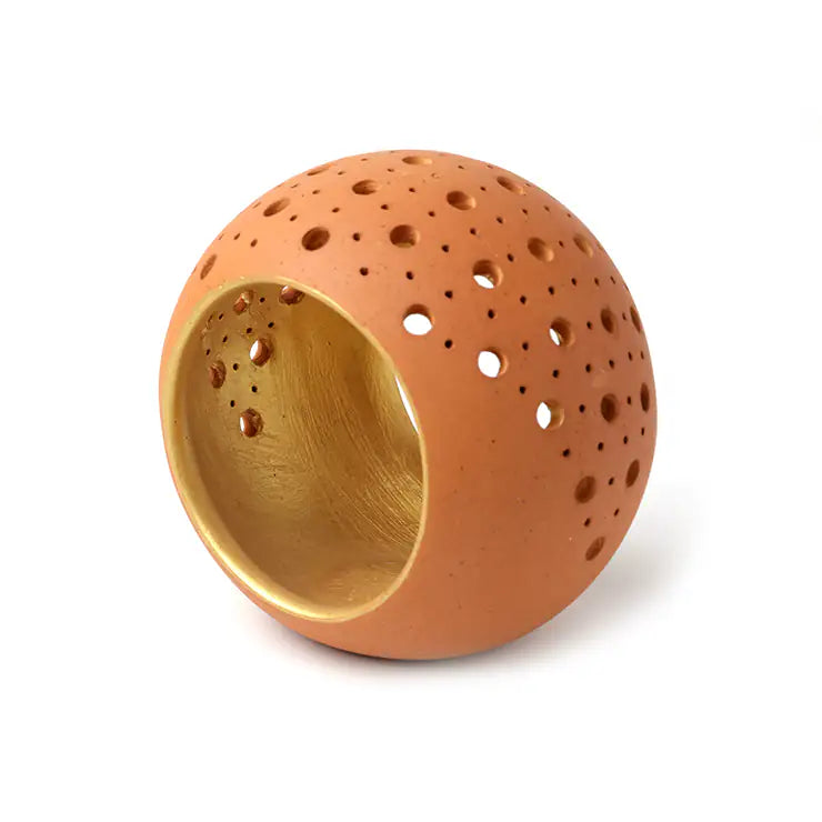 Handmade terracotta tealight holder with gold interior on white background