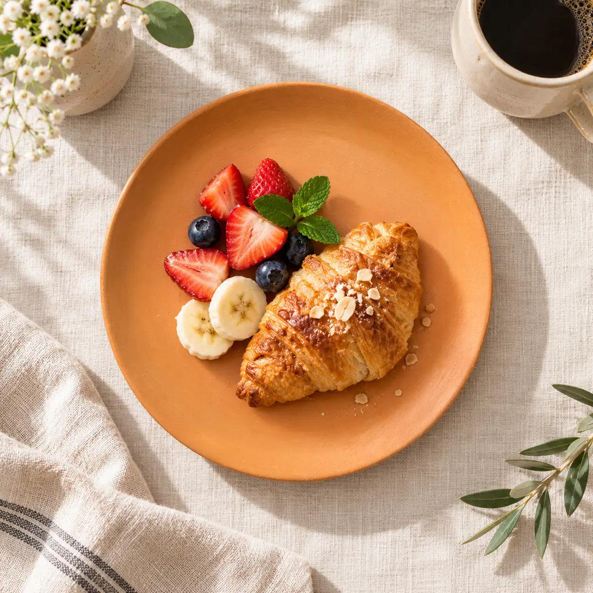 Terrapura handmade terracotta plate served with croissant and fresh fruit