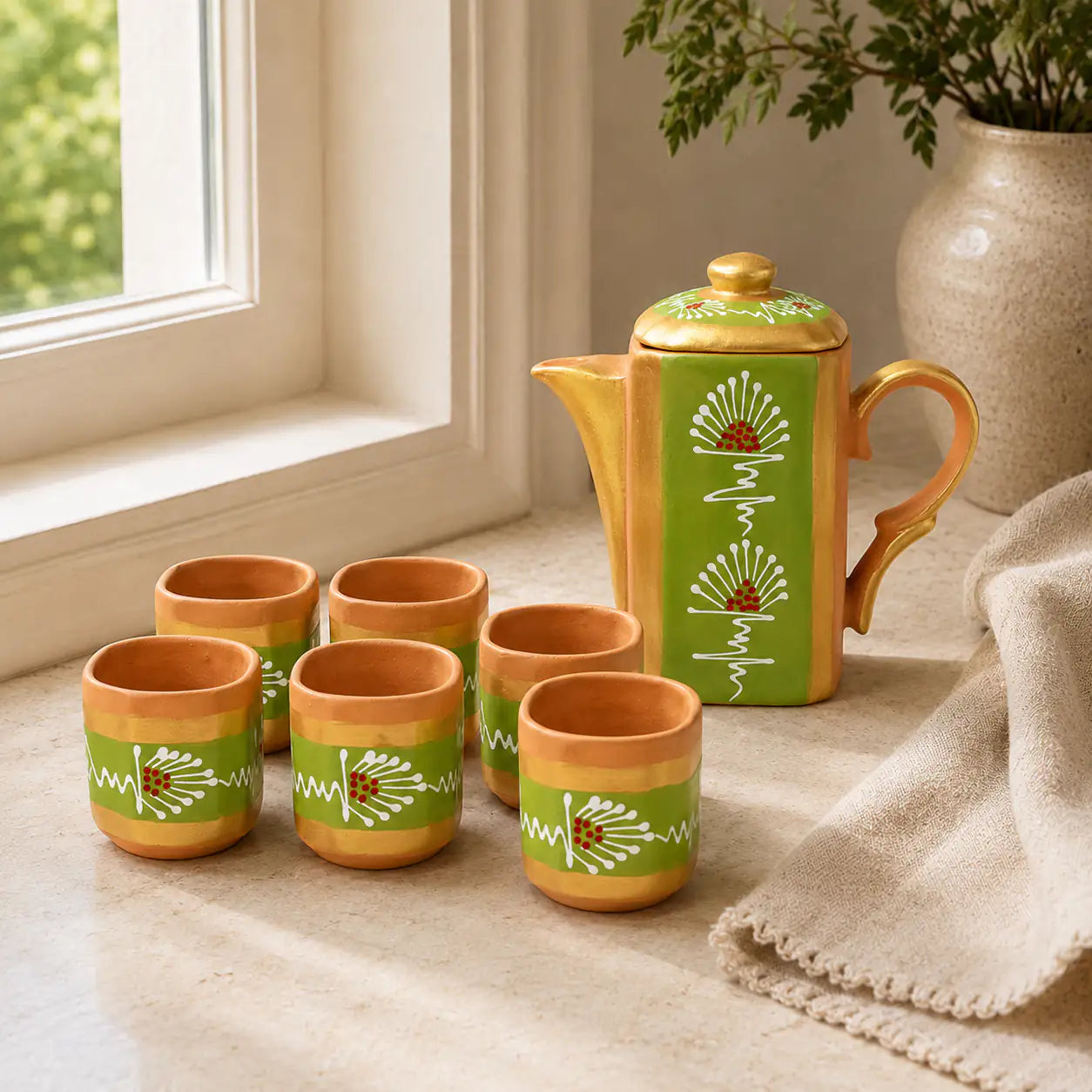 Terrapura green handpainted terracotta tea pot set with six cups on a window table