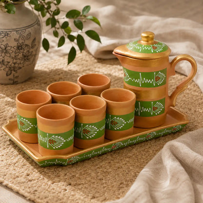 Clay tea set with cups and a teapot on a tray, featuring green patterns.