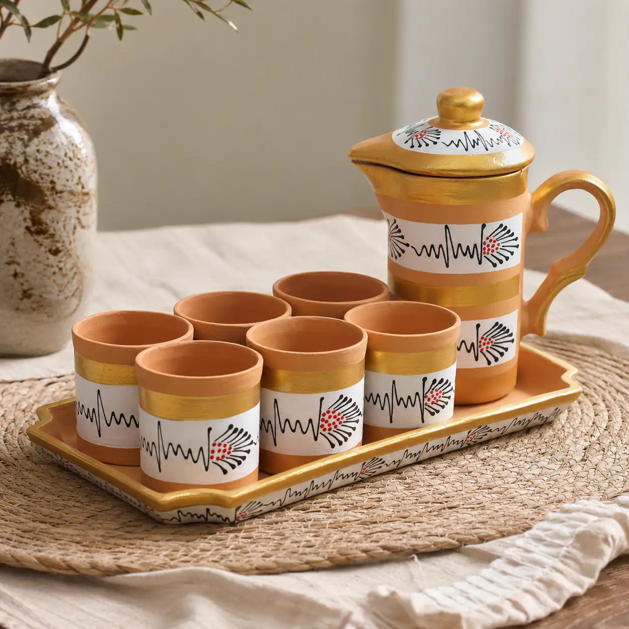 Ceramic tea set with cups and a teapot on a tray, featuring decorative patterns.