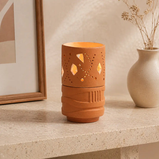 Terracotta tealight holder with light-toned interior and cutwork design