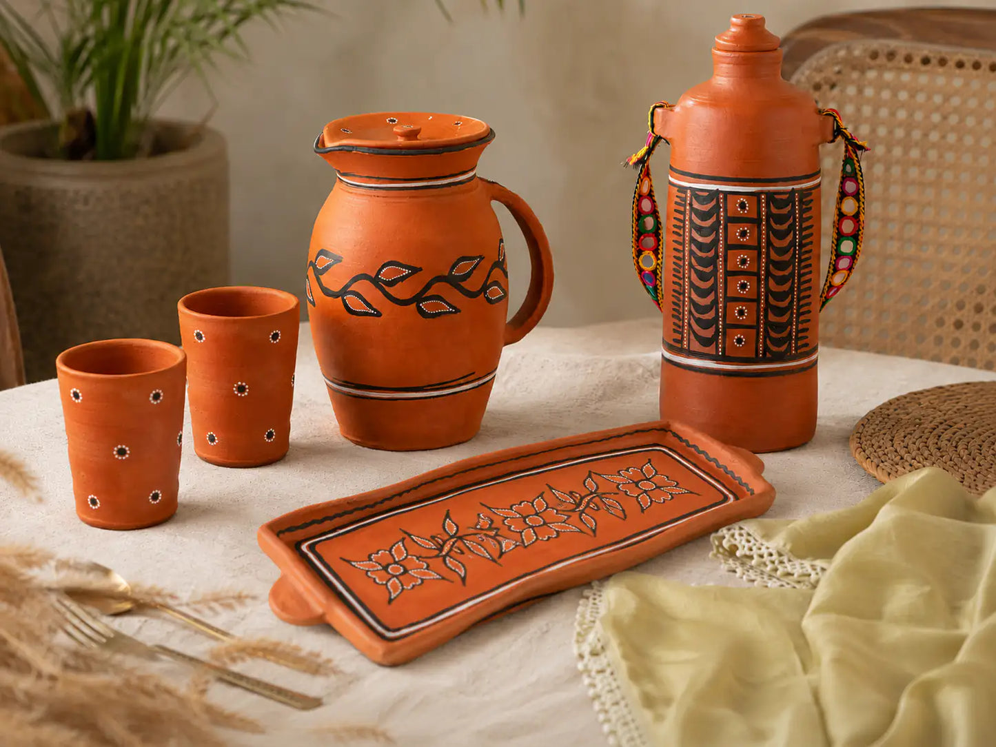 Clay tableware set with decorative patterns on a table.