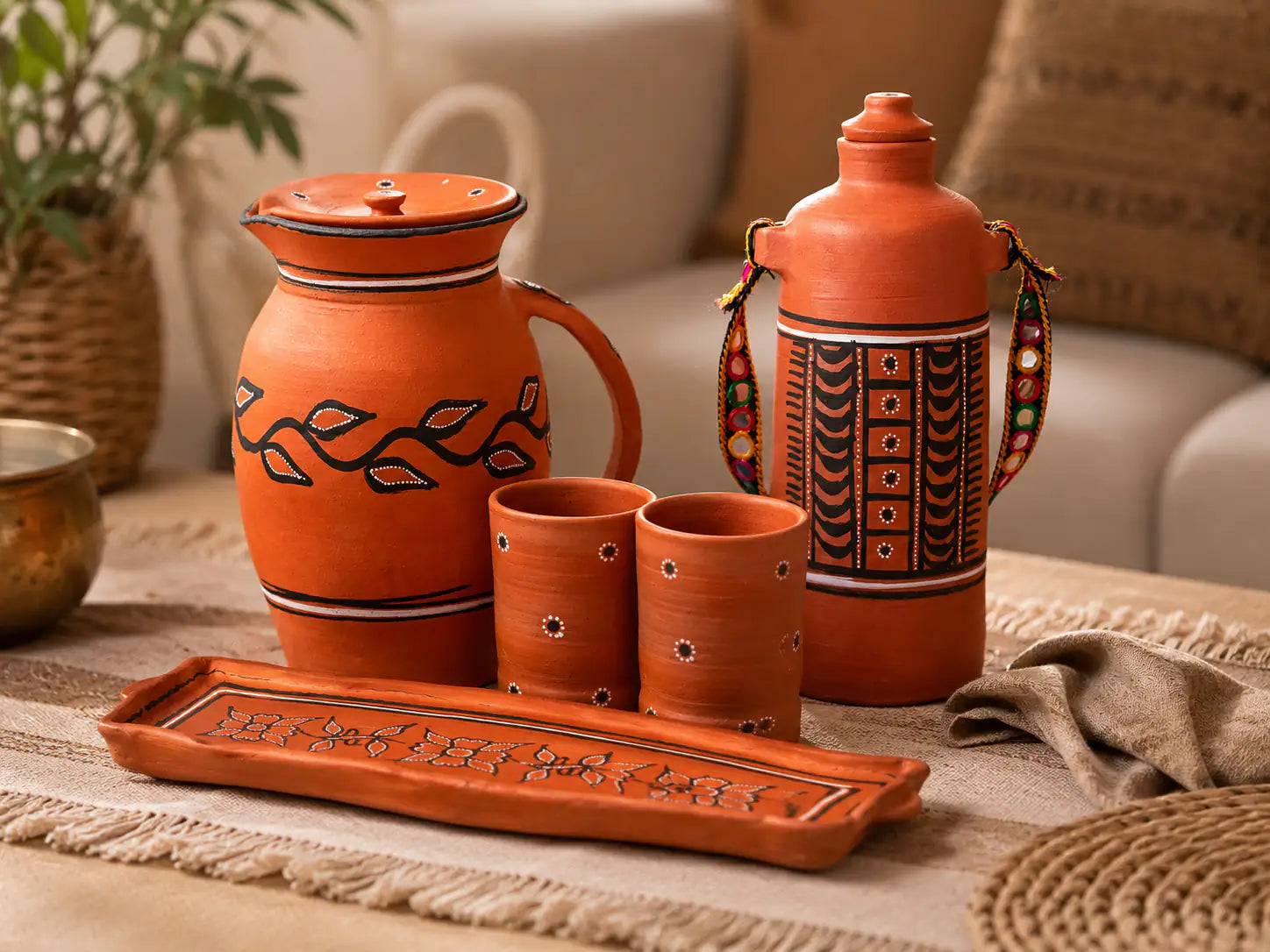 Set of terracotta pots with decorative patterns on a table.